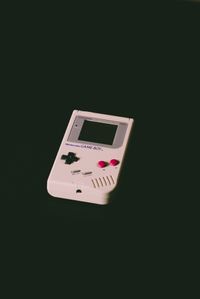A classic gameboy on a black background clipped into a triangle