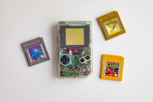 A clear gameboy and 3 games clipped into a triangle